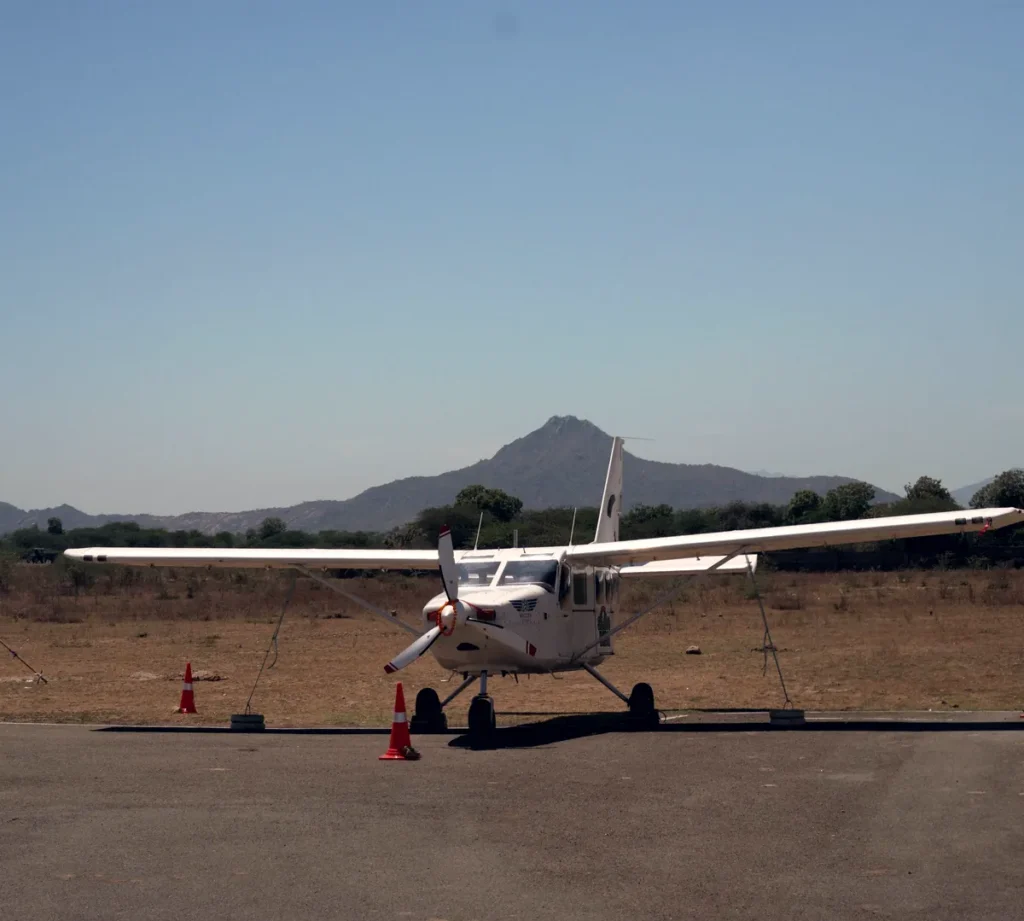 The jump aircraft parked on the apron, with a hill behind.