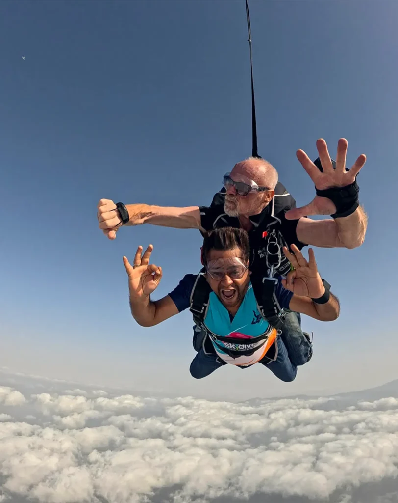 A tandem pair in freefall above a layer of cloud.